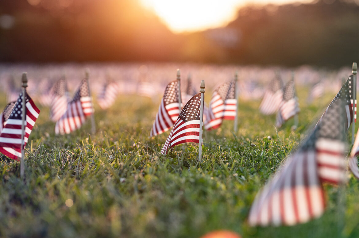 Early morning sun rise shining on American flags in the ground in Washington DC representing Live Oak's financing veteran financing programs and small business loans